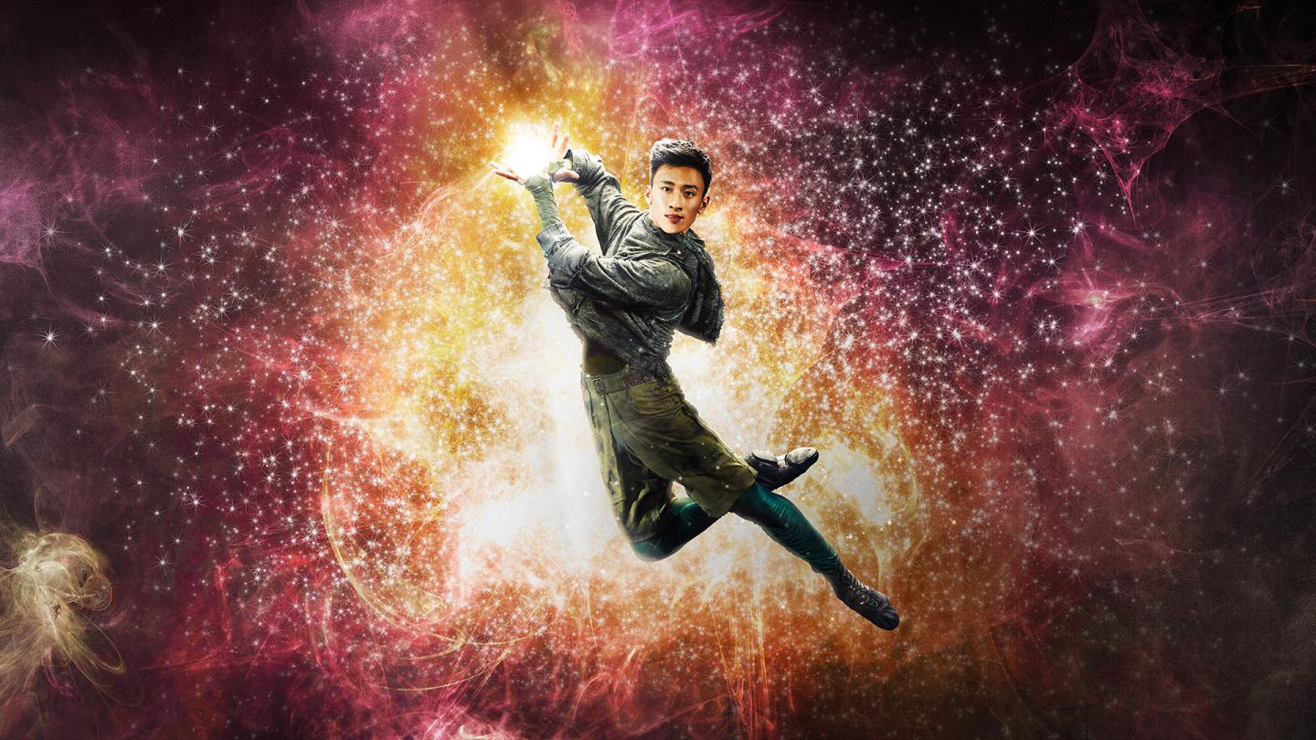 Dancer leaps holding light in his hands.