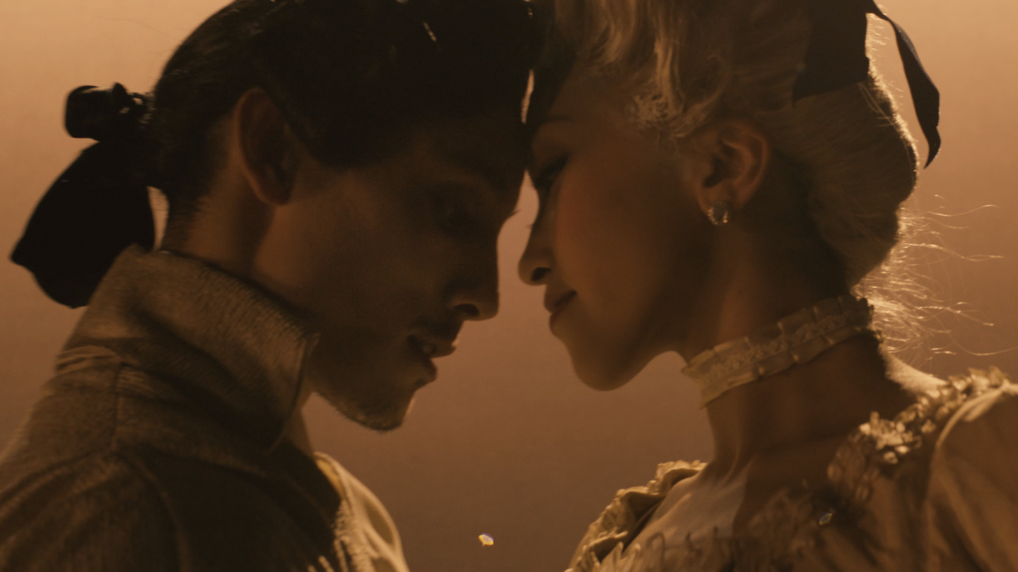 Two dancers meeting face to face with gold tones