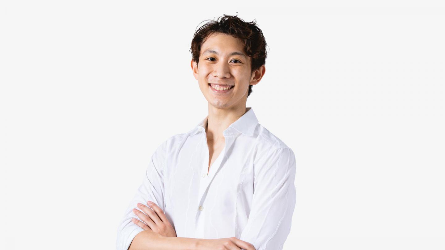 A headshot of a man smiling in a white shirt