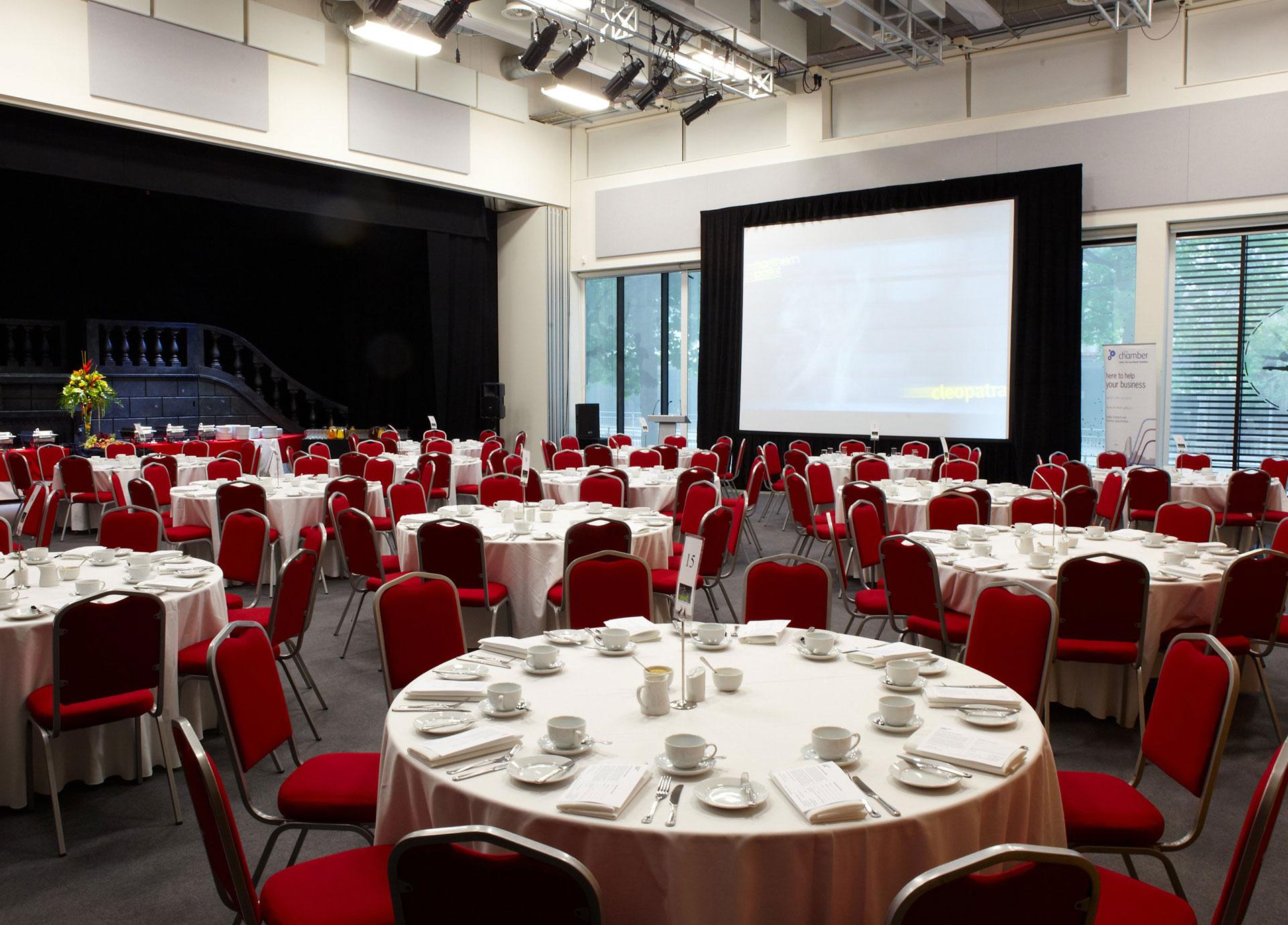 A room full of round tables dressed for an event
