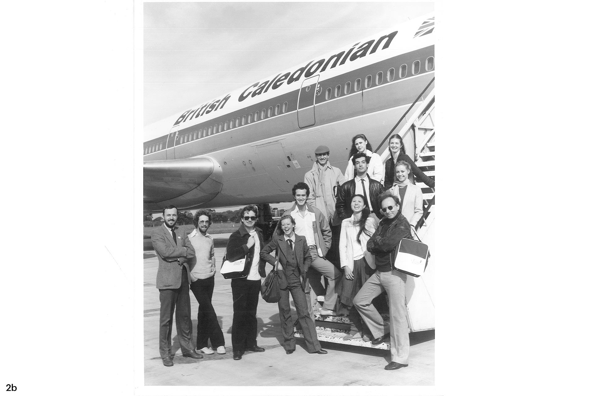 A group of people stand at the base of stairs leading to a flight