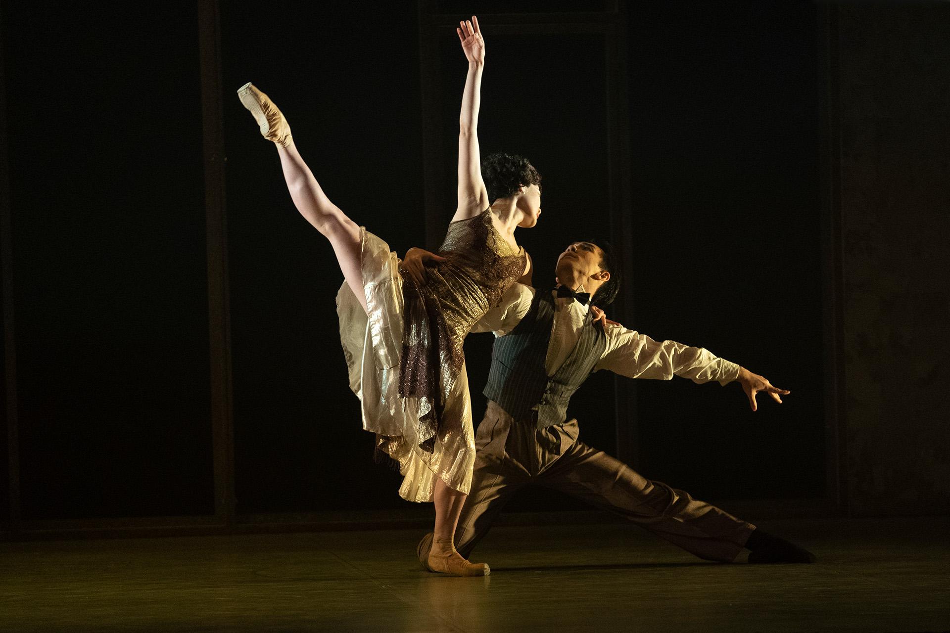 Daisy in arabesque gazing at a kneeling Jay