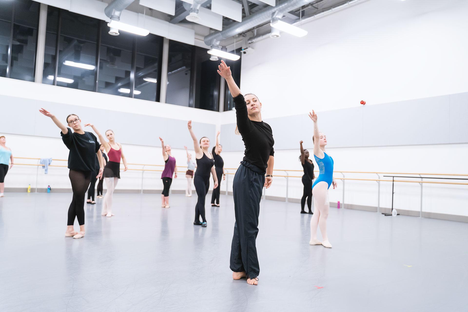Around 10 people participating in a ballet class