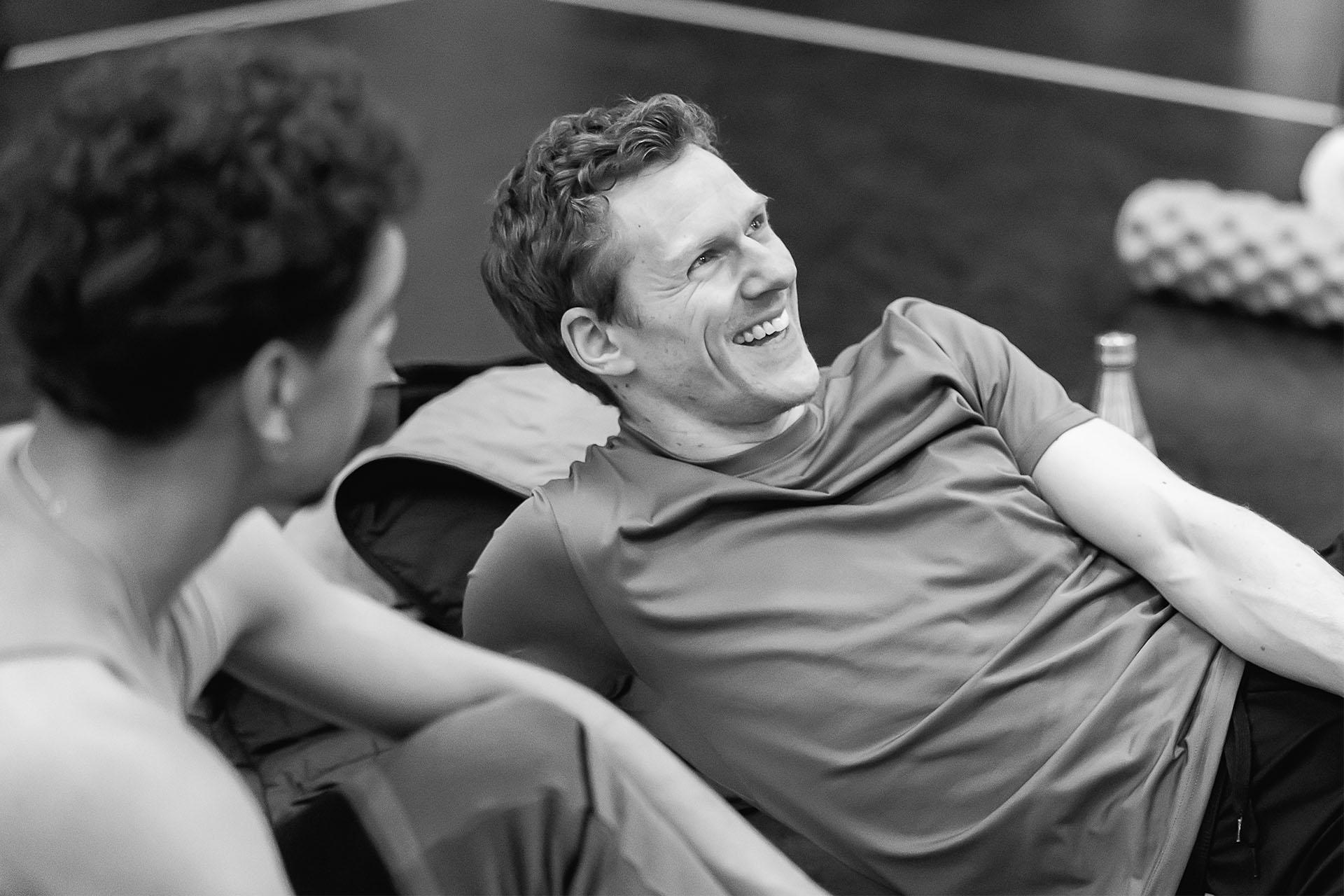 Black and white photo of man reclining and smiling