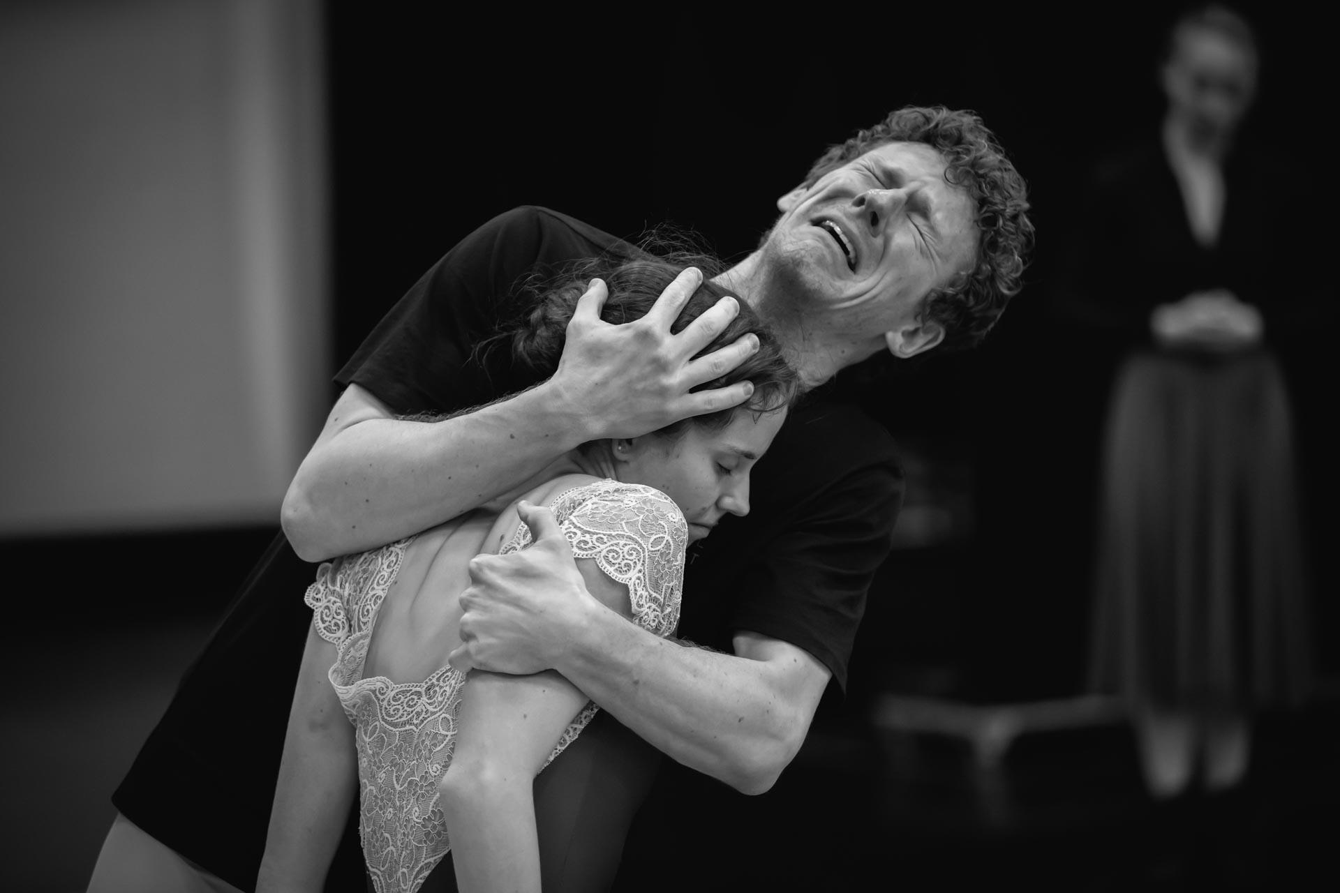 A man crying while holding a woman in black and white