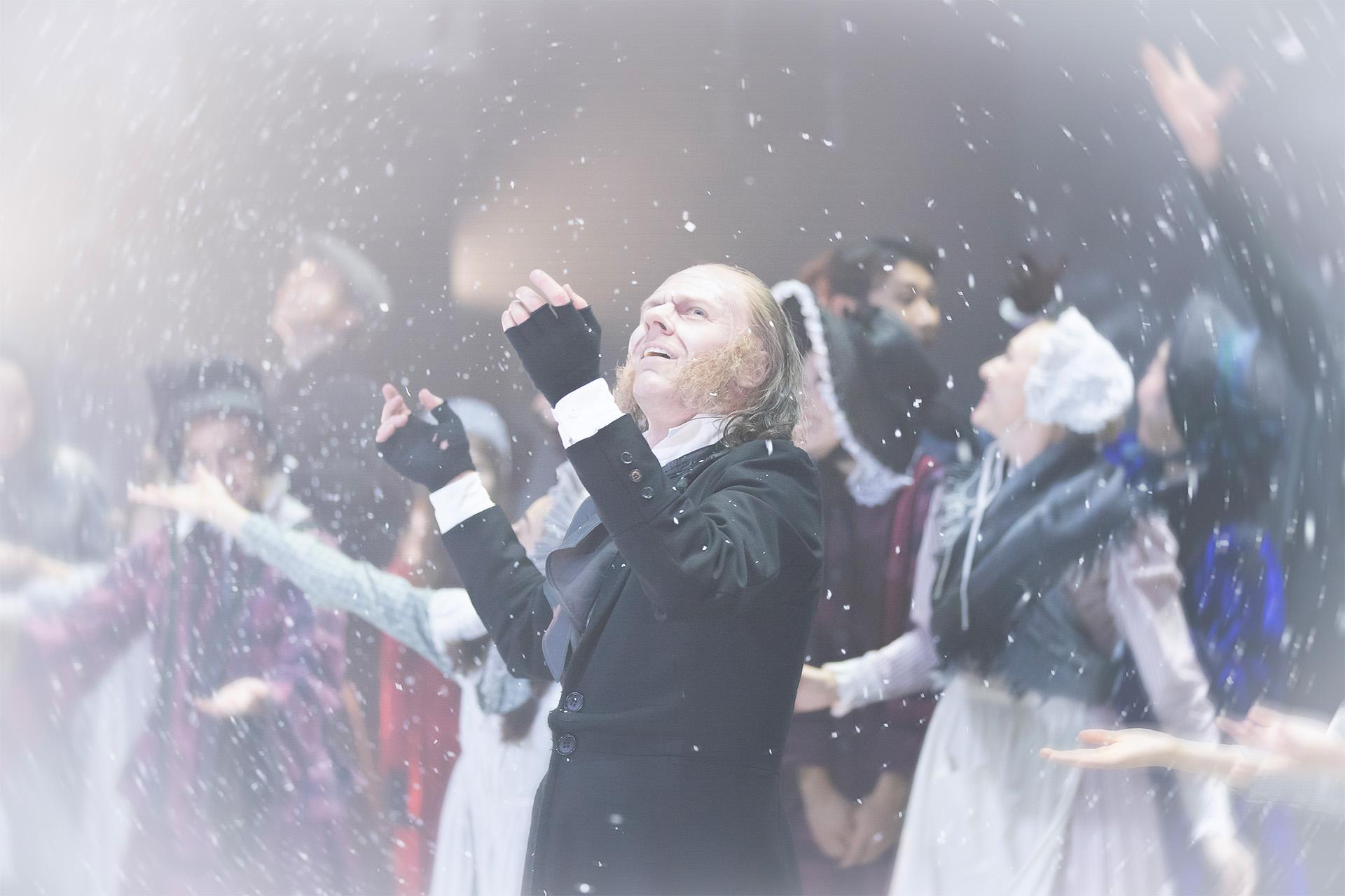 A dancer in Dickensian costume stood on stage marvelling at the snow falling