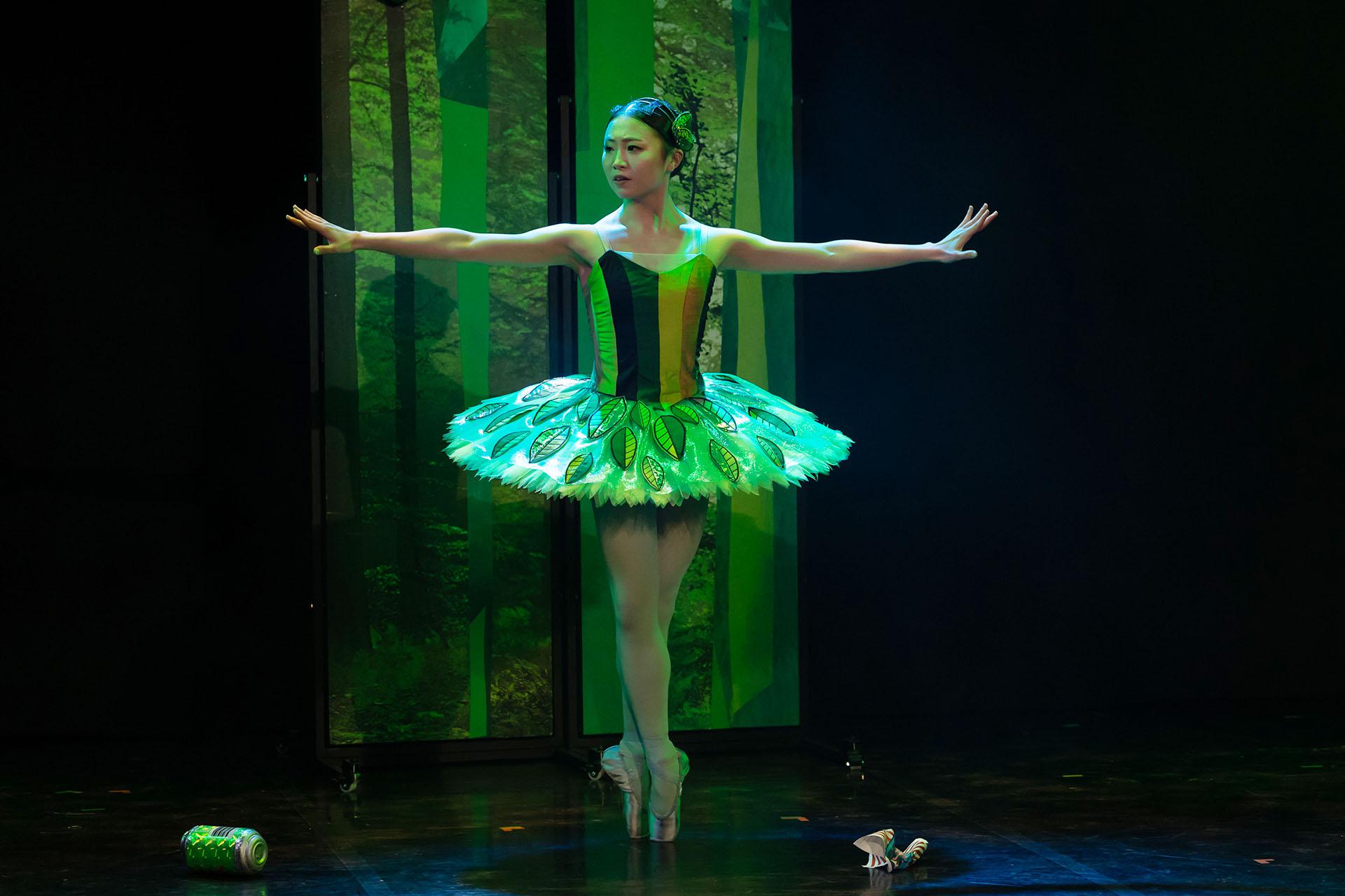 The Forest Spirit stands in the middle of the rubbish Hansel and Gretel have thrown on the floor, she stretches out her arms, asking them to stop.