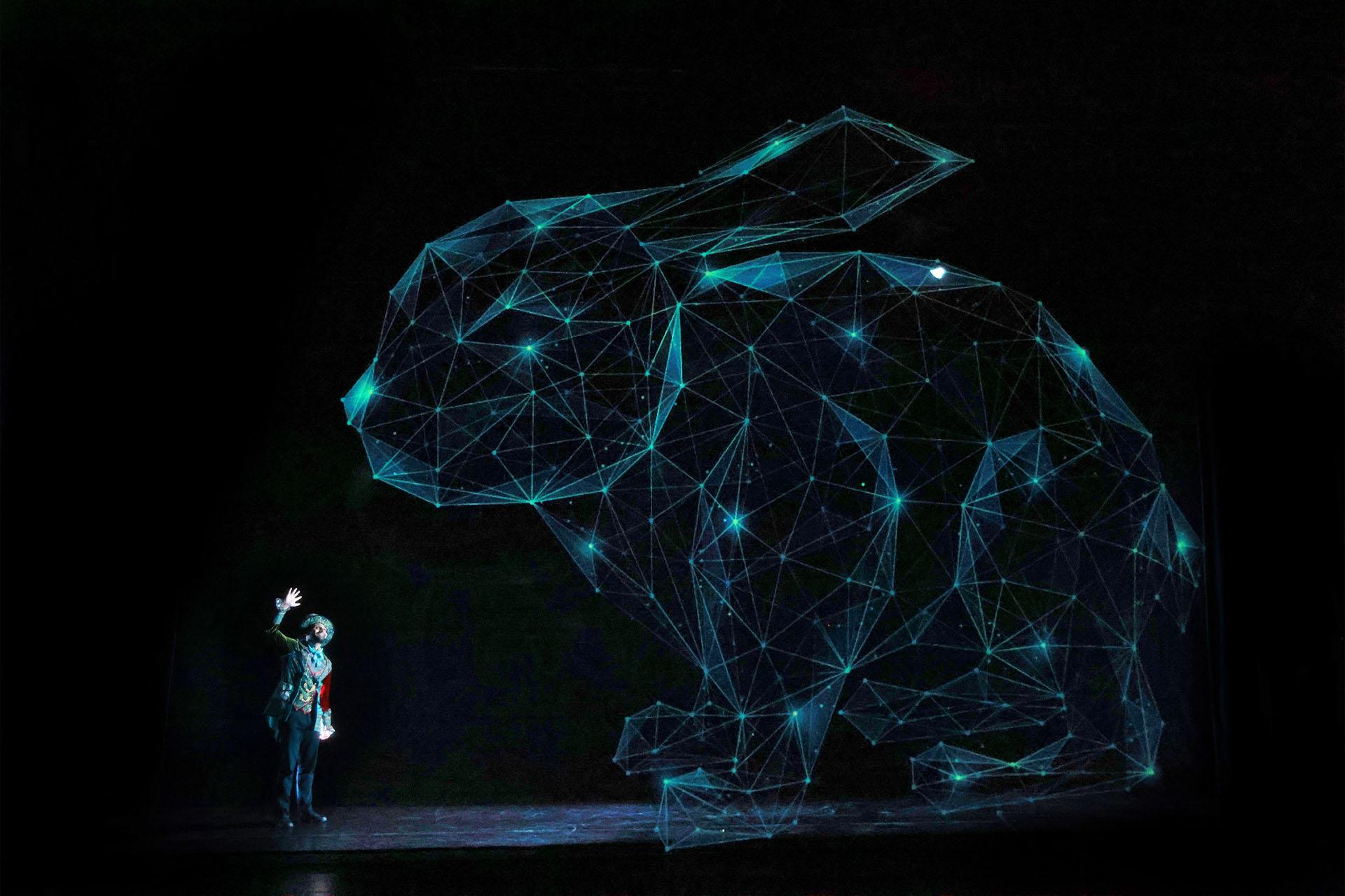 A man stands in front of and dwarfed by a rabbit made up of dots of light connected by thin glowing lines