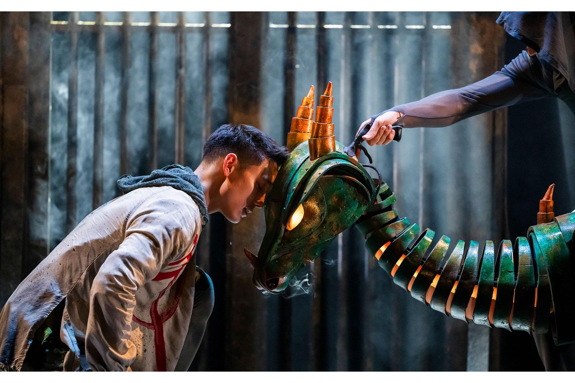 Merlin rests his forehead against the Dragon, both supplicant in respect