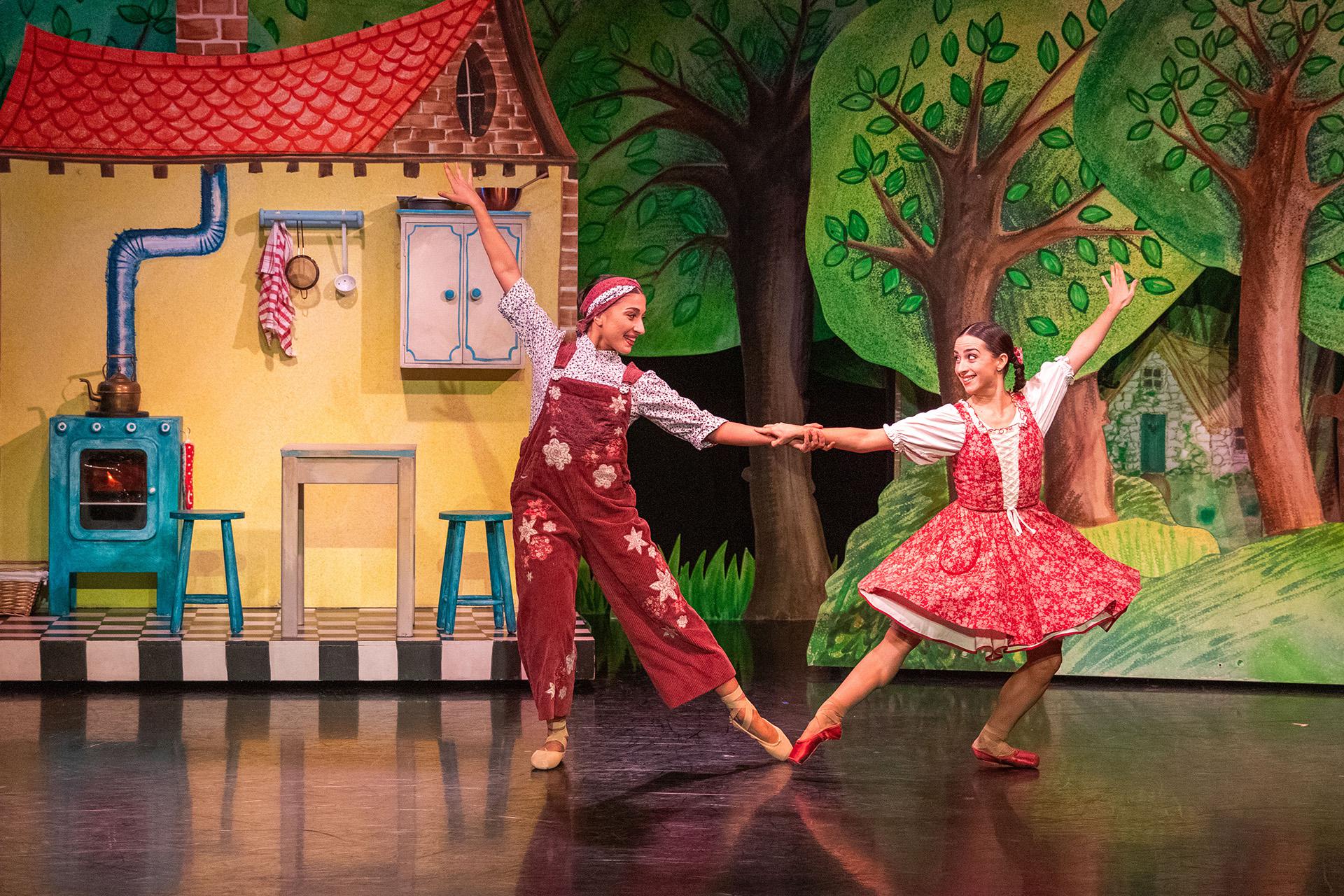 Little Red and her mother dancing in front of their yellow house by the forest