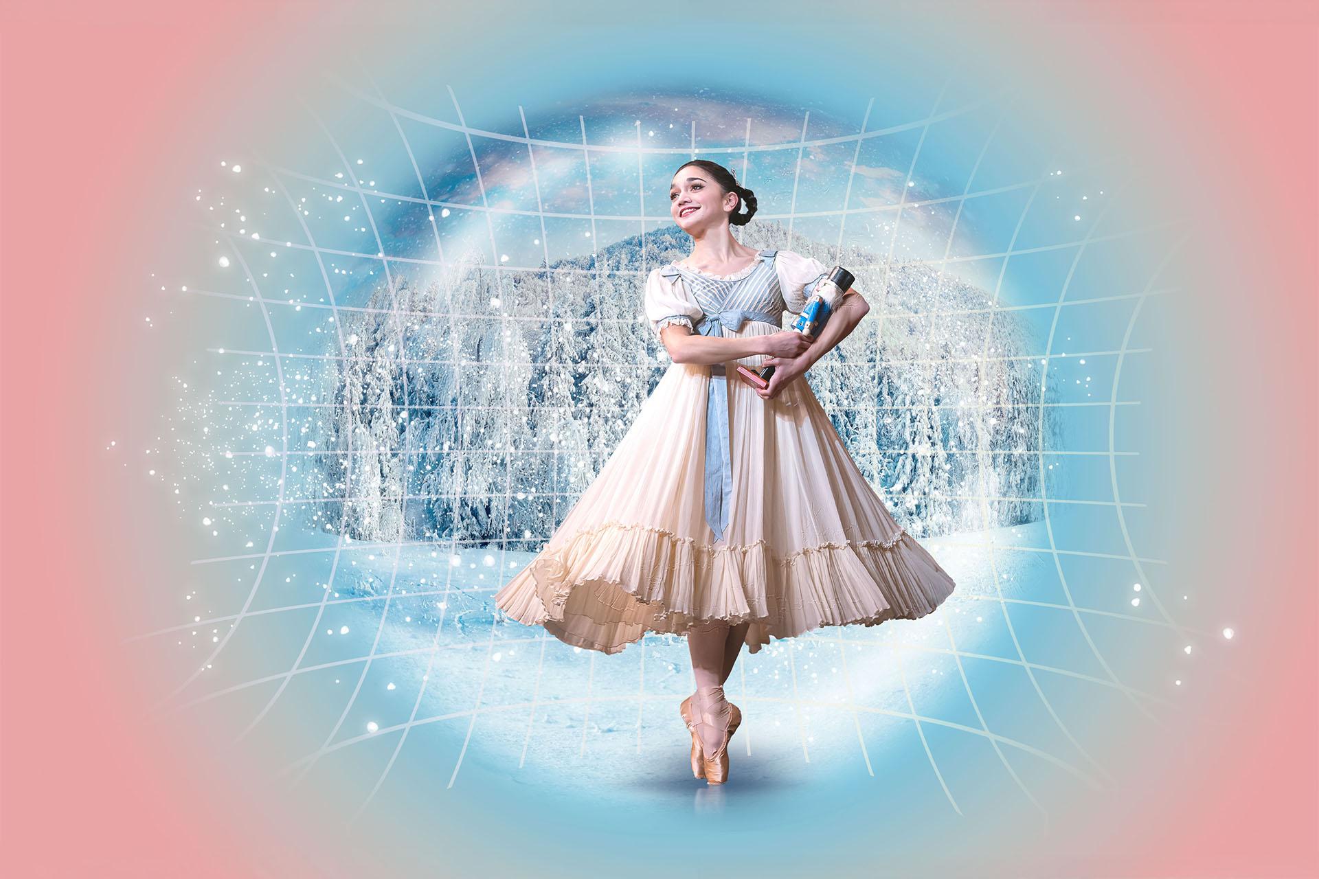 A dancer in Edwardian costume hold a Nutcracker doll in her arms, stands en pointe and smiles with childlike wonder