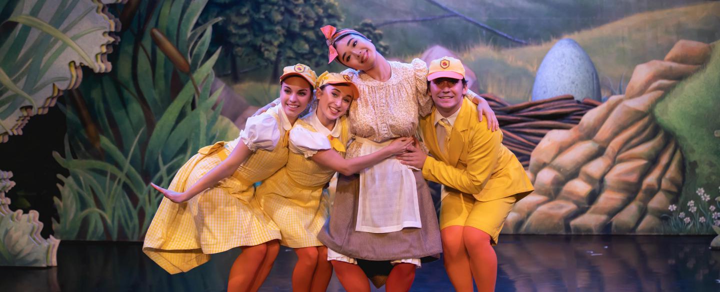 Three dancers dressed as ducklings hugging another dancer dressed as a Mother Duck