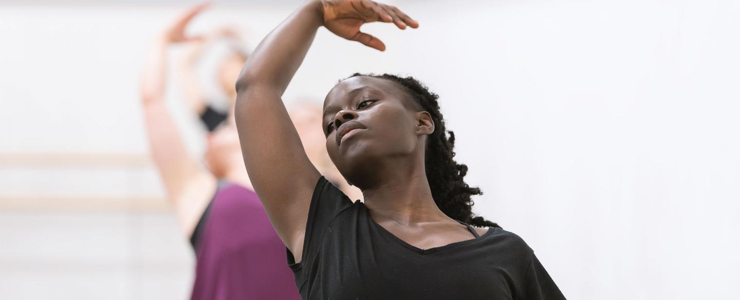 A woman leaning back on a ballet barre