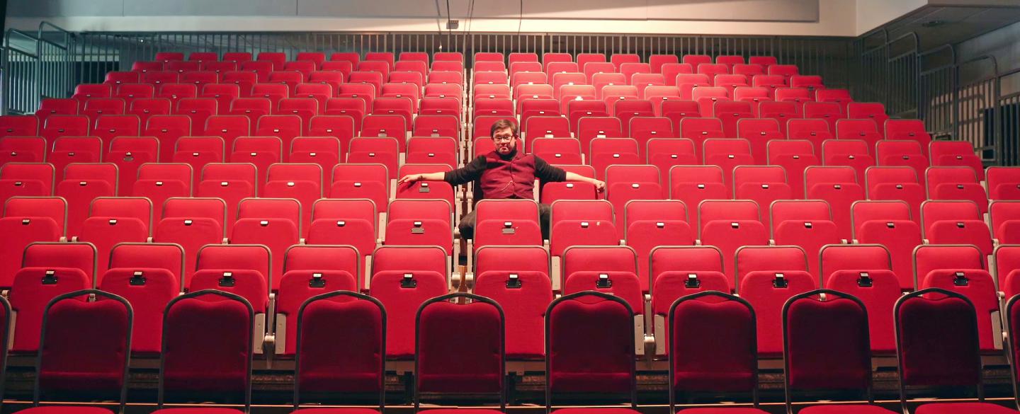 A man is sat on the seats in the Northern Ballet auditorium