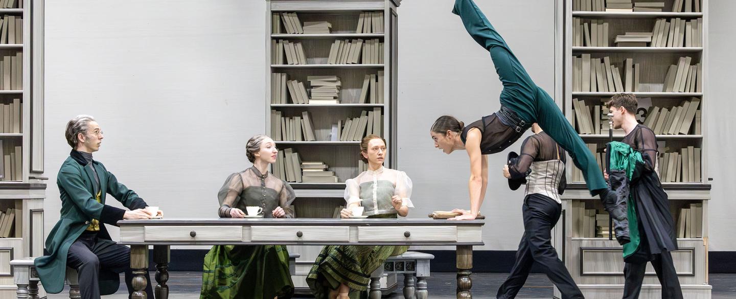 Around the dining table three sit and look on at Anne Lister whose lifting herself off the ground in anger