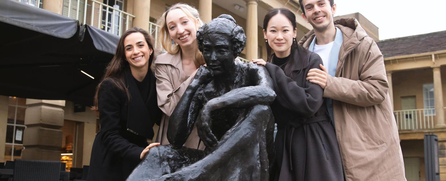 Four Northern Ballet dancers pose with a statue of Anne Lister.