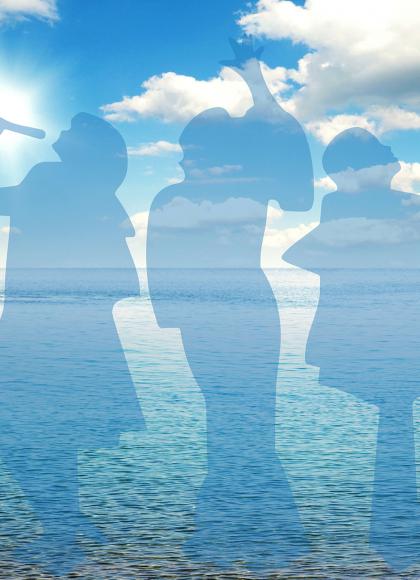 A silhouette of three people against a background of an ocean vista under an azure sky