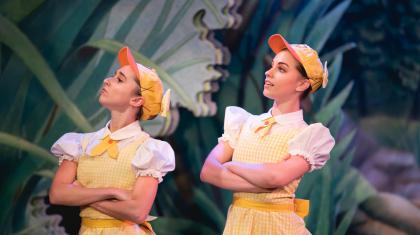 Two dancers in duckling costumes with arms folded