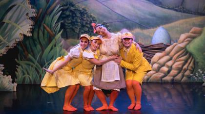 Three dancers dressed as ducklings hugging another dancer dressed as a Mother Duck