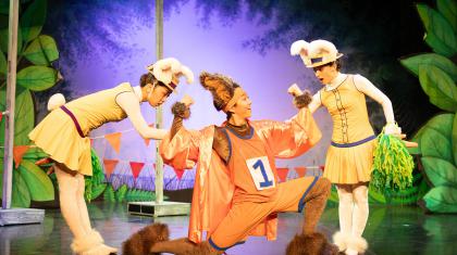 Three dancers in bunny costumes. Looks of excitement and joy 