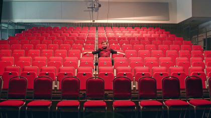 A man is sat on the seats in the Northern Ballet auditorium